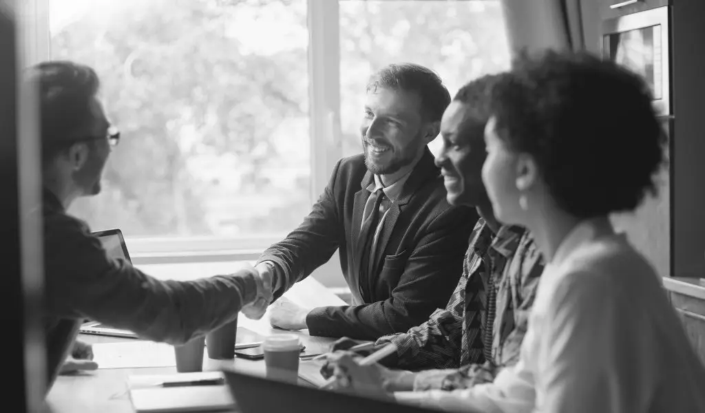 business-people-greet-each-other-at-the-table-after-merging-brands